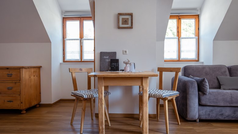 Leopold an der Ybbs, © © Niederösterreich Werbung/ Maximilian Pawlikowsky Gemütlicher Wohnbereich mit Holztisch, zwei Stühlen und Sofa.