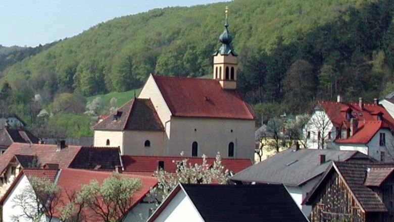 Wallfahrtskirche Maria Raisenmarkt, © Wallfahrtskirche Maria Raisenmarkt Wallfahrtskirche Maria Raisenmarkt in einer ländlichen Umgebung mit Hügeln im Hintergrund.