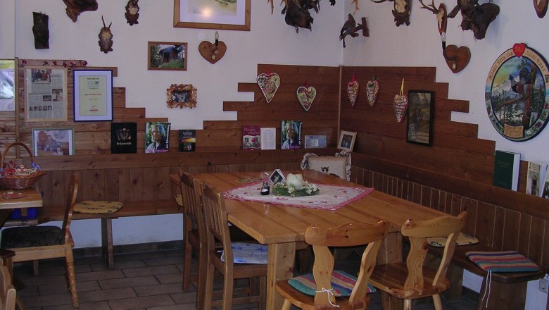 Jausenstation Holzhof, © Holzhof Gemütliche Stube mit Holzmöbeln und Jagdtrophäen an den Wänden.