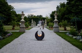 Historischer Hofgarten Stift Seitenstetten, © Unrath Ein Kiesweg im historischen Hofgarten des Stifts Seitenstetten mit Skulpturen und Pflanzen, im Vordergrund eine Feuerstelle.