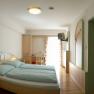 Standard Zimmer, © zVg Kirchenwirt Ein Hotelzimmer mit Doppelbett, Schreibtisch, Fernseher und Badezimmer.
