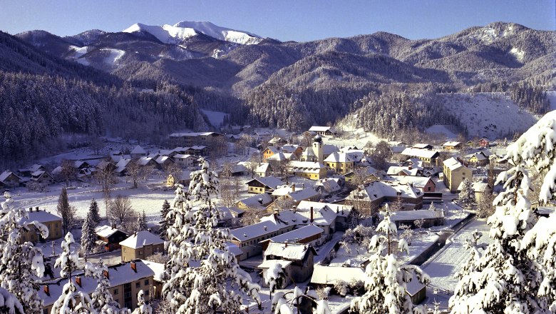 St. Aegyd vom Osterkogel aus, © ARGE Genusstourismus St. Aegyd Winterliche Landschaft von St. Aegyd mit schneebedeckten Häusern und Bergen im Hintergrund.