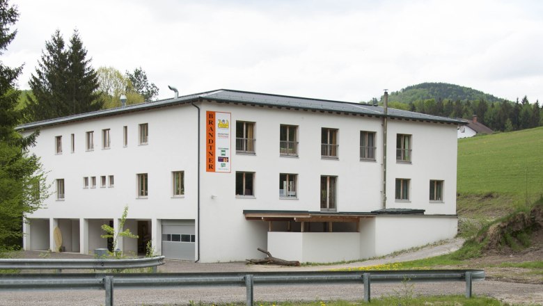 Brandtner Seminar, © manuPicts_Manuela Holzer-Horny Ein weißes Gebäude mit der Aufschrift 'Brandtner' in ländlicher Umgebung.