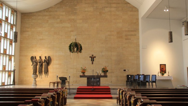 Innenansicht Pfarre Hinterbrühl, © Werner Zemann Innenansicht einer Kirche mit Altar, Bänken und religiösen Skulpturen.