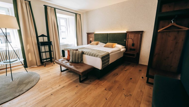 Einfach mal über Nacht bleiben – die Wohlfühlzimmer laden ein., © Zum Goldenen Löwen Modern eingerichtetes Hotelzimmer mit Doppelbett, Holzboden und großen Fenstern.