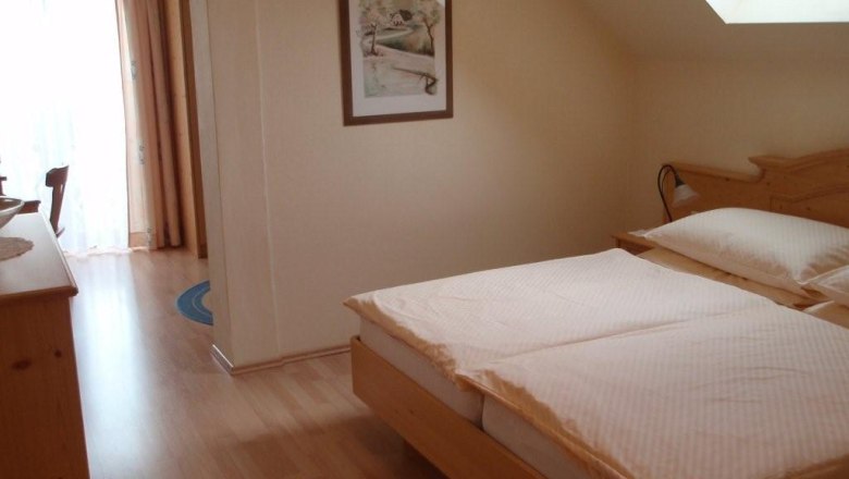 Pension "Haus Karner", © Pension "Haus Karner" Gemütliches Schlafzimmer mit Doppelbett, Dachfenster und Holzmöbeln.