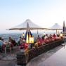 Terrassenhotel Rose, © Hotel Rose Terrasse eines Restaurants mit Gästen, Blumen und Sonnenschirmen bei Sonnenuntergang.