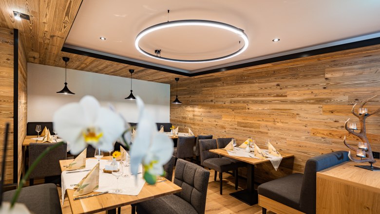 Restaurant, © Christian Kremsl Gemütliches Restaurant mit Holzwänden, modernen Leuchten und elegant gedeckten Tischen.