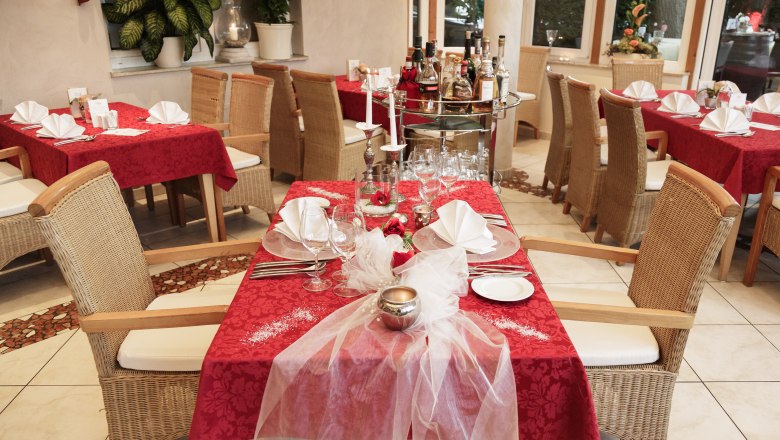 Roter Hahn, © Familie Widgruber Elegantes Restaurant mit roten Tischdecken und gedeckten Tischen.