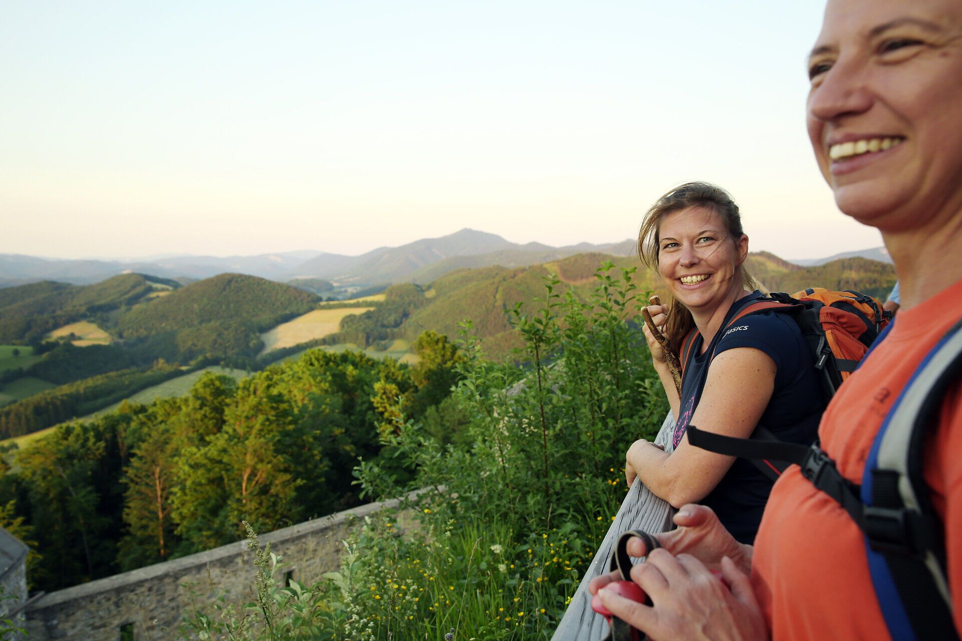 In der warmen Sommerluft strahlen die Gesichter der Wanderer vor Freude und Entdeckungslust. Umgeben von sanften Hügeln und üppigem Grün, genießen sie die atemberaubende Aussicht auf die malerische Landschaft. Der Pilgerweg Via Sacra lädt dazu ein, die Seele baumeln zu lassen und die Natur in vollen Zügen zu erleben.