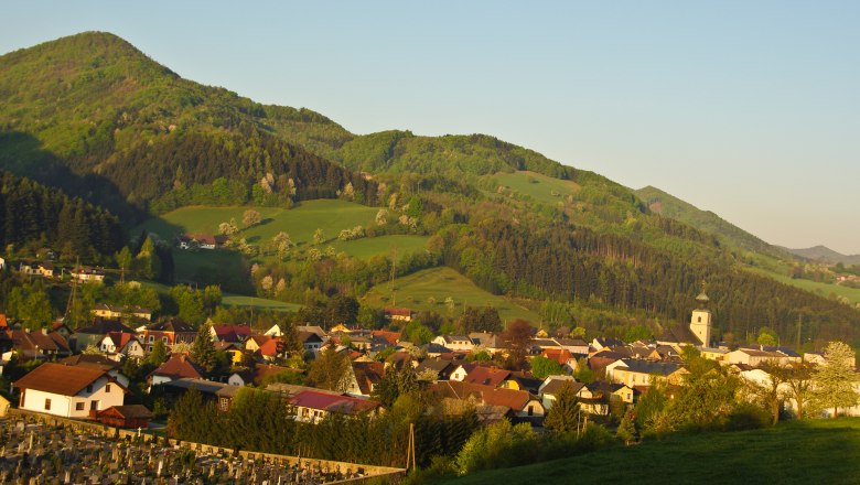 Panorama von St. Veit an der G&ouml;lsen mit Kirche und Bergen im Hintergrund.