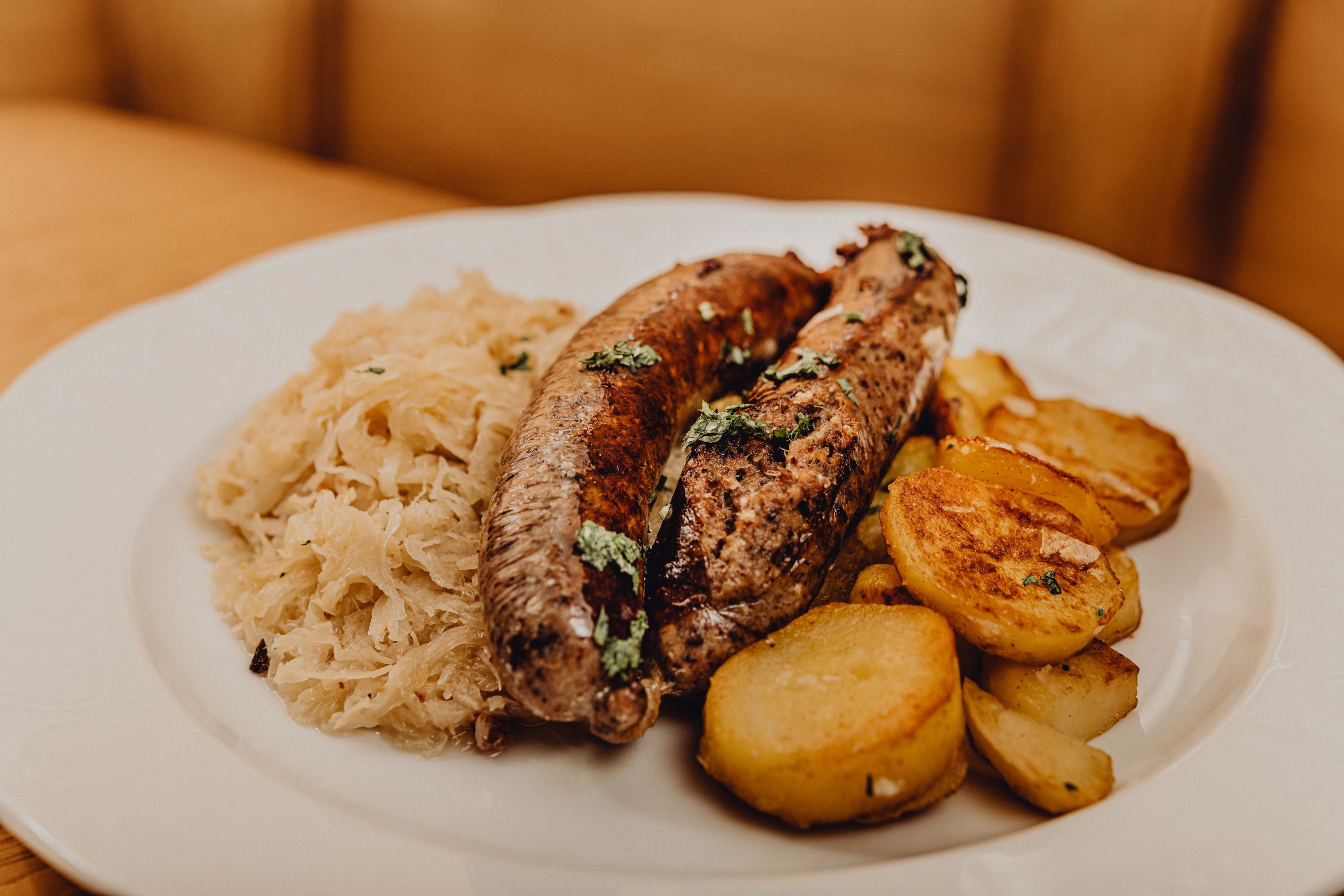 Ein Teller mit Leberwurst, Röstkartoffeln und Sauerkraut.