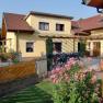 Gelbes Haus mit Garten und Fahrr&auml;dern vor der T&uuml;r.
