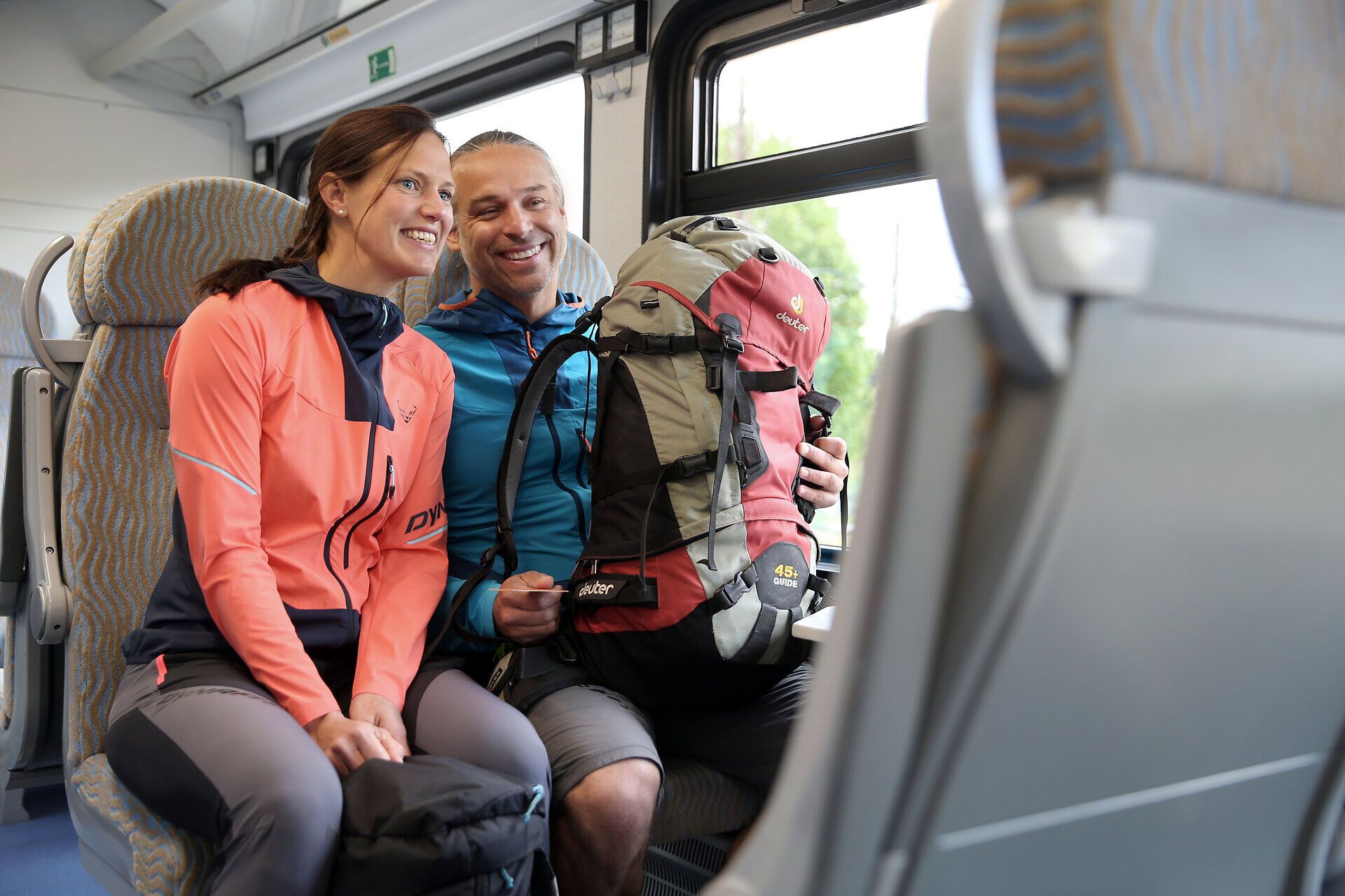 Ein Paar genießt die entspannte Atmosphäre während ihrer Pilgerwanderung. Umgeben von der atemberaubenden Natur, strahlen ihre Gesichter Freude und Abenteuerlust aus. Die Vorfreude auf die Erlebnisse entlang der Via Sacra ist spürbar.