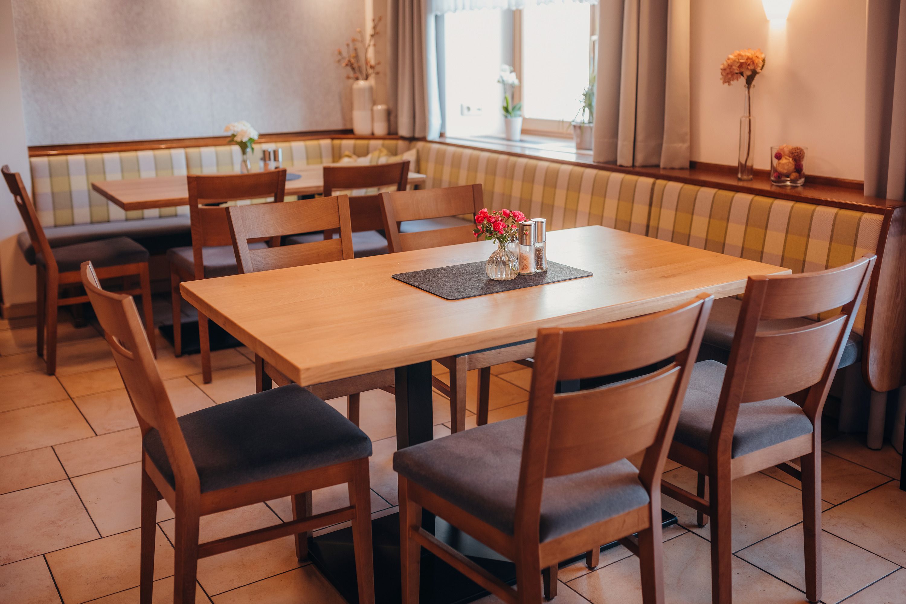 Gemütliches Restaurant mit Holztischen und gepolsterten Sitzbänken.