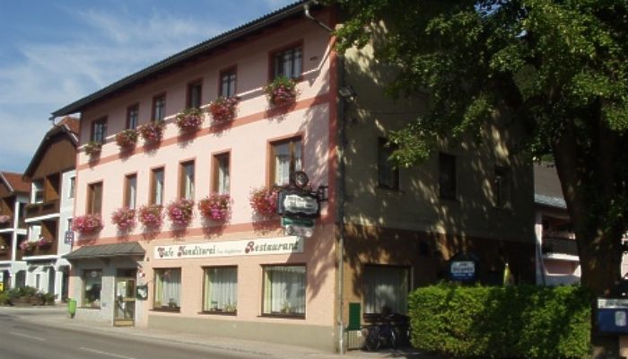 Ein traditionelles Gasthaus mit rosa Fassade und Blumenkästen an den Fenstern.