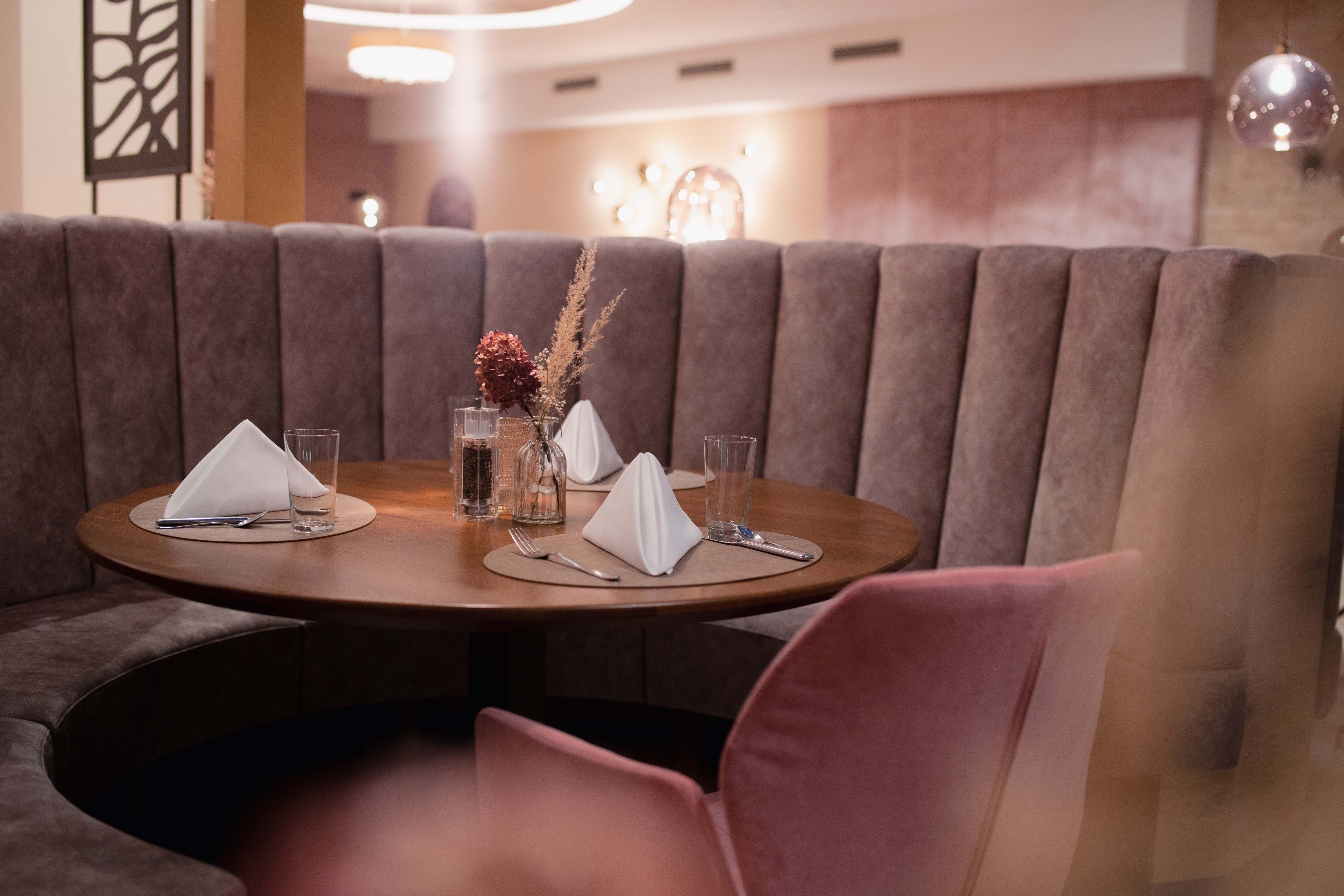 Elegantes Restaurant mit runder Sitzbank und gedecktem Tisch.
