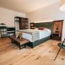 Modern eingerichtetes Hotelzimmer mit Doppelbett, Holzboden und stilvollen M&ouml;beln.
