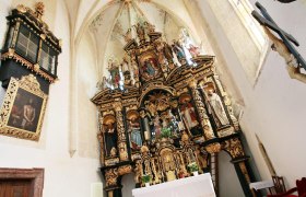 Innenansicht der Wallfahrtskirche Annaberg mit reich verziertem Altar und religiösen Statuen.