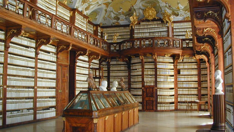 Innenansicht der Bibliothek im Stift Seitenstetten mit reich verzierten Holzregalen und B&uuml;sten.