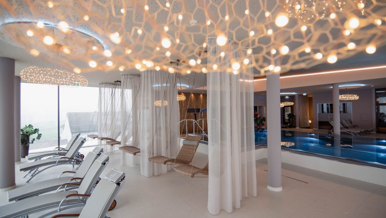 Moderner Spa-Ruhebereich mit Liegestühlen, Hängesesseln und Pool.