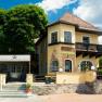 Eingang des Hotel Kaiser Franz Josef mit gelber Fassade und Balkon.