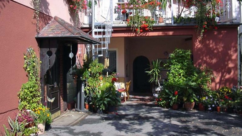 Eingang einer Fr&uuml;hst&uuml;ckspension mit vielen Pflanzen und Blumen.