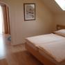 Gem&uuml;tliches Schlafzimmer mit Doppelbett, Dachfenster und Holzm&ouml;beln.