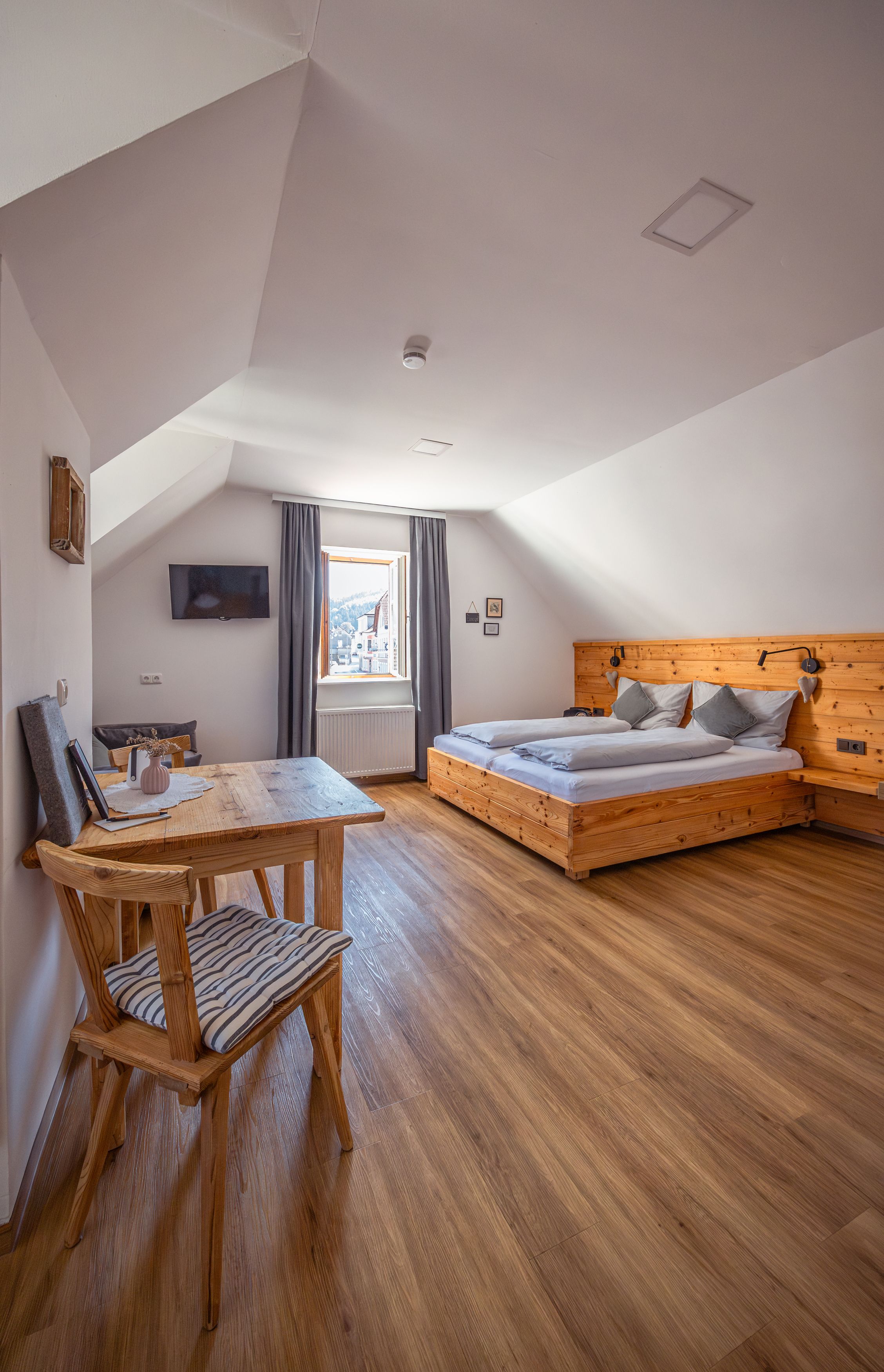 Gemütliches Schlafzimmer mit Holzmöbeln und Dachschräge.