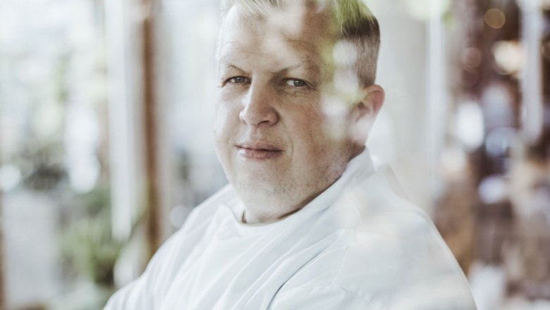 Portr&auml;t eines Mannes in wei&szlig;em Hemd, durch ein Fenster fotografiert.