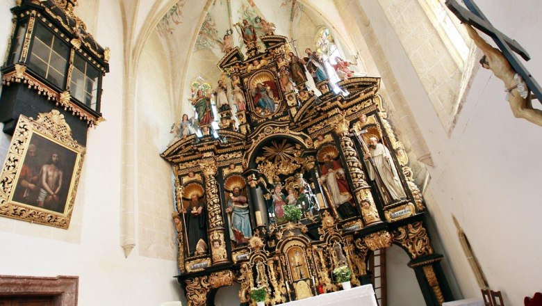 Innenansicht der Wallfahrtskirche Annaberg mit reich verziertem Altar und religi&ouml;sen Statuen.