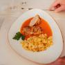Krautroulade mit Kartoffeln und So&szlig;e auf wei&szlig;em Teller serviert.