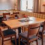 Gemütliches Restaurant mit Holztischen und gepolsterten Sitzbänken.