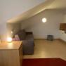 Innenansicht einer Ferienwohnung mit Sofa, Tischlampe und K&uuml;chenzeile.