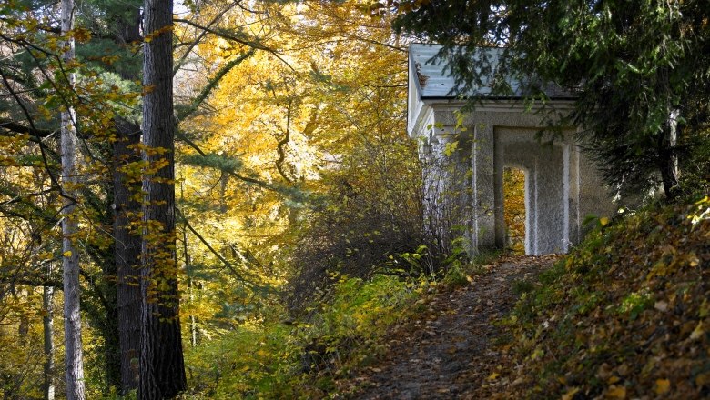 Herbstszene im Stiftspark Lilienfeld mit Laub und kleinem Geb&auml;ude.