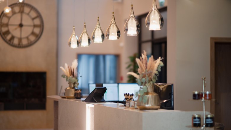 Elegante Hotelrezeption mit modernen Lampen und Dekorationen.