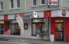 Außenansicht eines Sportgeschäfts namens Strametz mit Skiern und Sportbekleidung im Schaufenster.