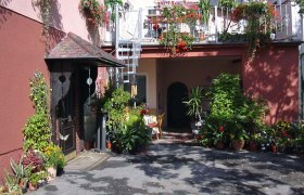 Eingang einer Fr&uuml;hst&uuml;ckspension mit vielen Pflanzen und Blumen.