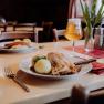 Schweinsbraten mit Knödel und Bier in einem gemütlichen Restaurant.