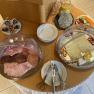 Ein Fr&uuml;hst&uuml;cksb&uuml;ffet mit Aufschnitt, K&auml;se, Gem&uuml;se, Geb&auml;ck und Getr&auml;nken auf einem Tisch.