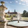 Brunnen im Garten des Stifts Seitenstetten mit barocker Architektur im Hintergrund.