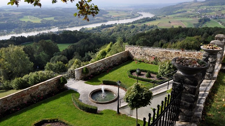 Garten mit Brunnen und Blick auf die Donau.