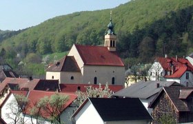 Wallfahrtskirche Maria Raisenmarkt in einer l&auml;ndlichen Umgebung mit H&uuml;geln im Hintergrund.