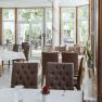 Innenansicht eines eleganten Restaurants mit gedeckten Tischen und gro&szlig;en Fenstern.