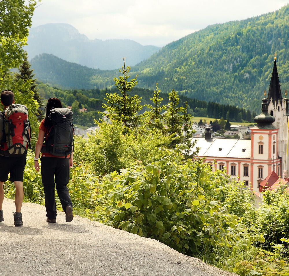 Die sanften Hügel und die majestätische Basilika im Hintergrund laden zu einer besinnlichen Pilgerwanderung ein. Umgeben von üppigem Grün und der frischen Bergluft, erleben Wanderer hier eine harmonische Verbindung von Natur und Spiritualität.