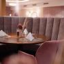 Elegantes Restaurant mit runder Sitzbank und gedecktem Tisch.