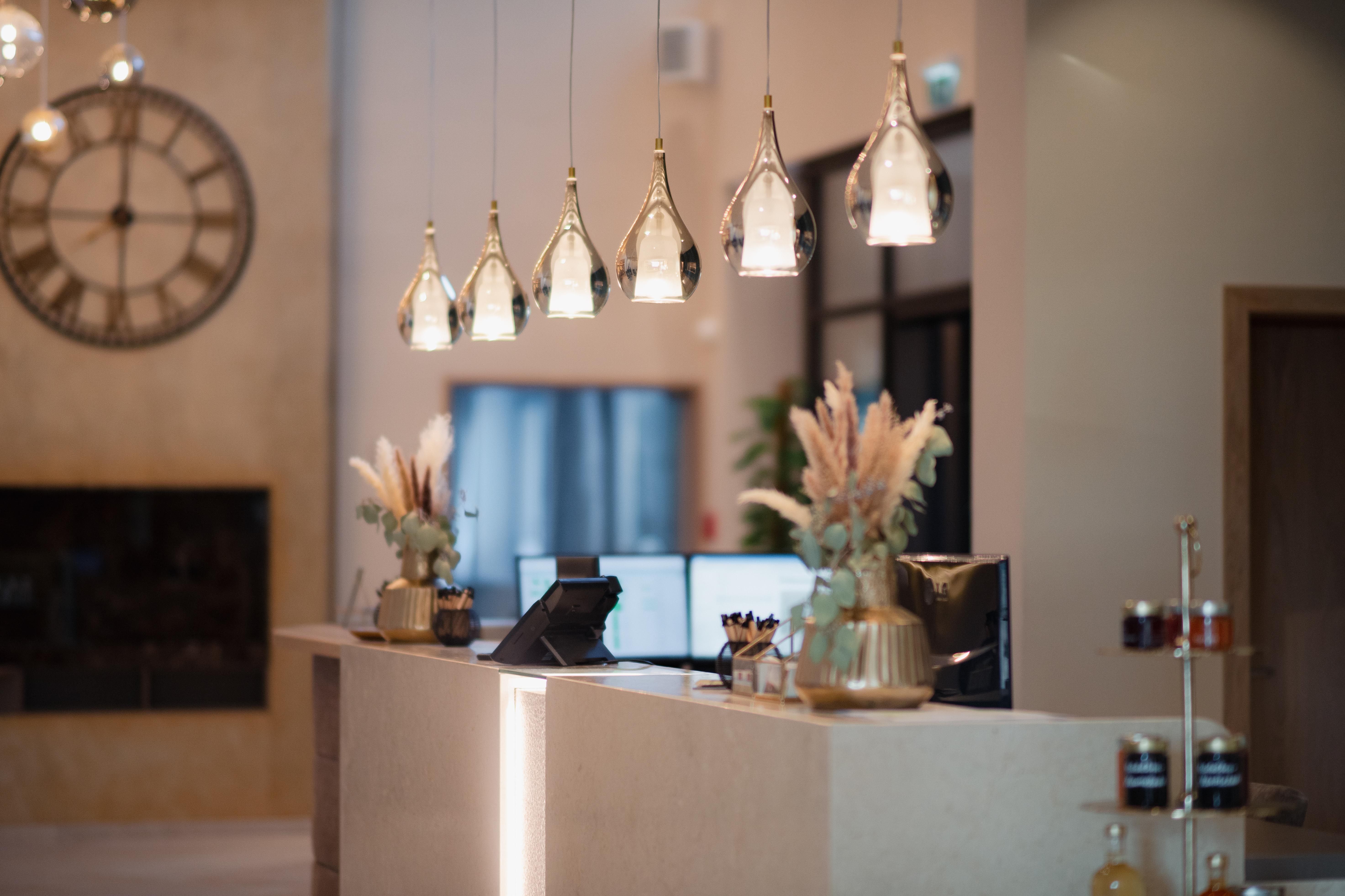 Elegante Hotelrezeption mit modernen Lampen und Dekorationen.