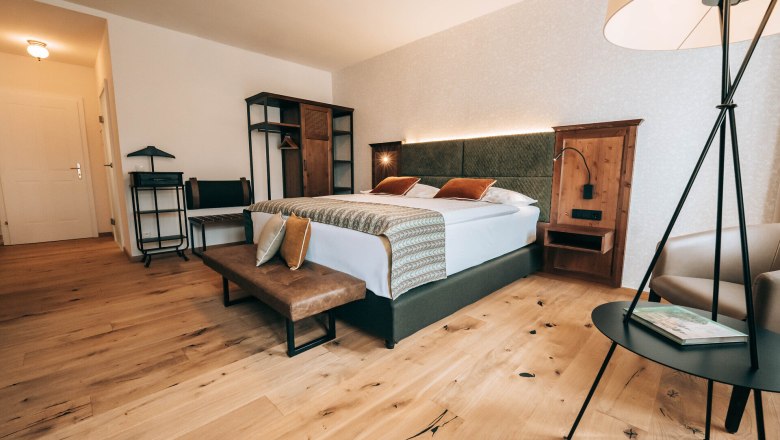 Modern eingerichtetes Hotelzimmer mit Doppelbett, Holzboden und stilvollen M&ouml;beln.