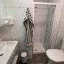 Modernes Badezimmer mit Dusche, Waschbecken und Toilette.