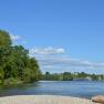 Flusslandschaft mit B&auml;umen und einem Schiff auf der Donau.